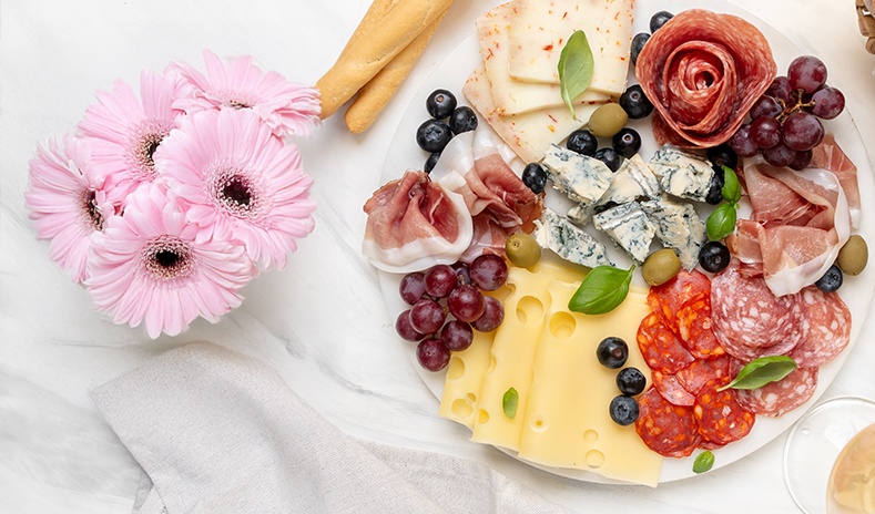 photo of a beautiful spring charcuterie board with cheeses and meats
